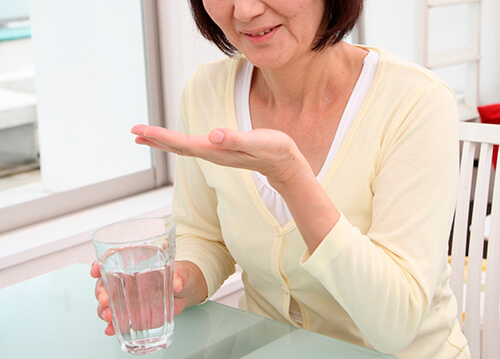 薬を飲む女性